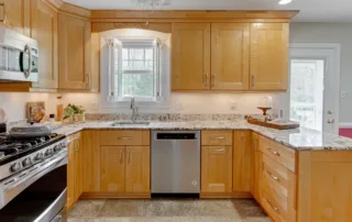 Beautiful new kitchen with wooden cabinets, stone countertops, and tile flooring by Colorwheel Painting in Germantown