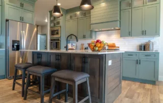 Modern farmhouse kitchen with wooden island and gray-green painted cabinets
