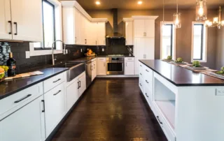 Beautiful new remodeled kitchen with dark wood floors and white cabinet refinishing done by Colorwheel Painting in Waukesha, WI