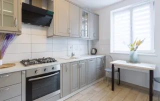 Home kitchen with bright window and newly painted gray cabinets
