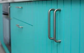 Kitchen cabinets painted in a glossy bright blue color
