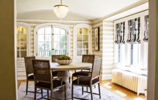 A dining room with a round table and chairs.